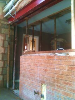 How do I knock through a supporting wall safely